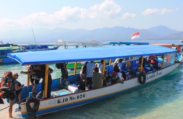 Public boat with people in the water on Gili Air
